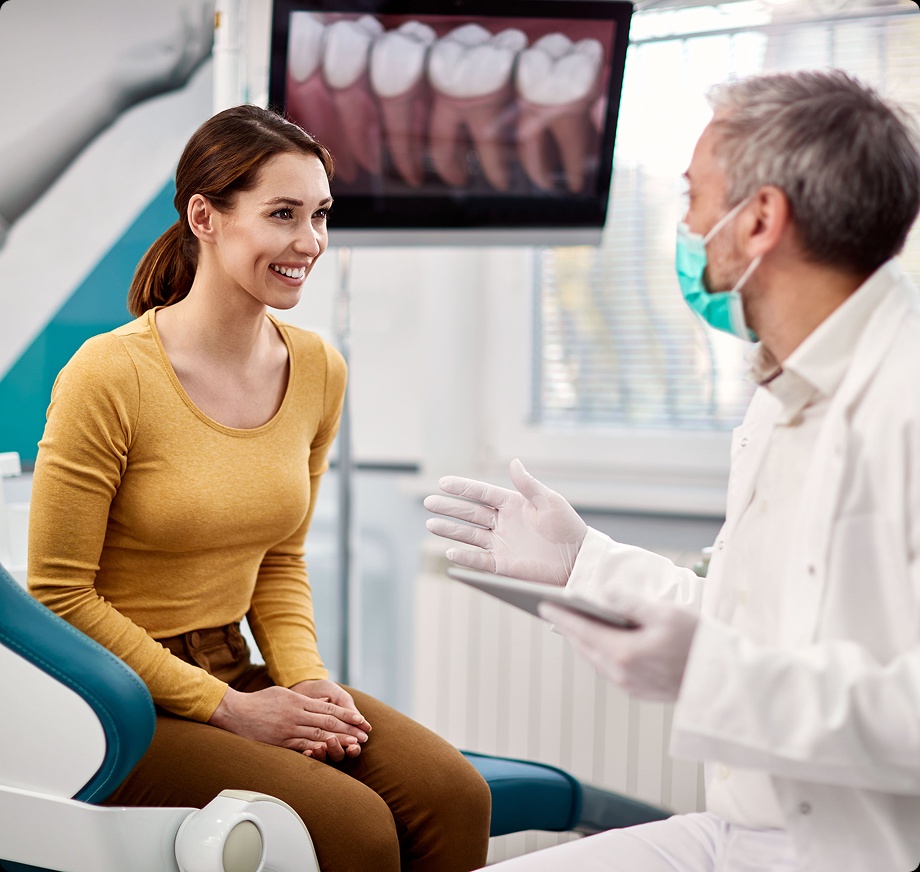Young woman talking to dentist and smiling